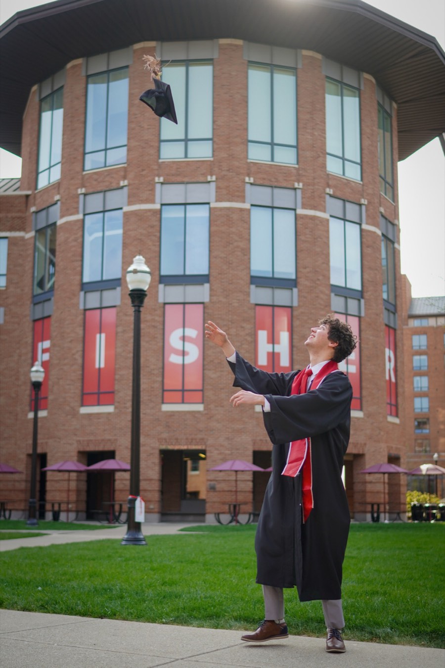 Alec Levine tossing his graduation cap outside Ohio State's Fisher College of Business
