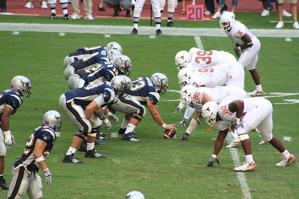 Rice and Texas football teams aligned at the line of scrimmage
