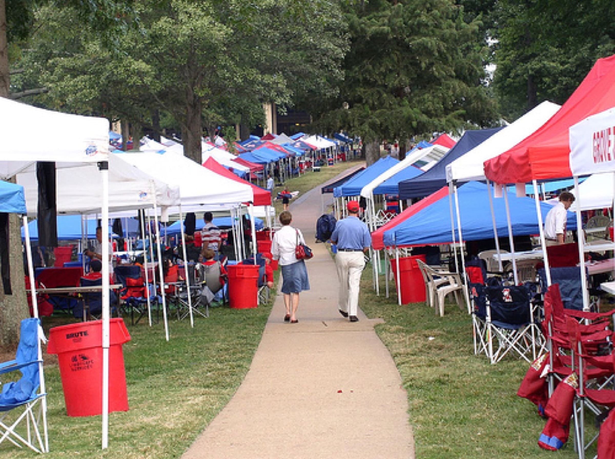 Fans gathering beneath the trees in The Grove at Ole Miss